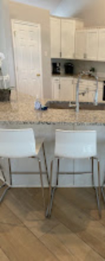 Clean kitchen with white cabinets and a granite counter