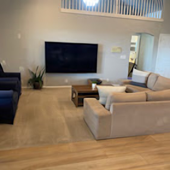 Clean living room with a large sofa and wall-mounted TV
